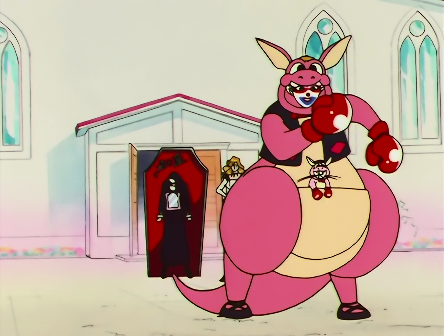 Kigurumiko’s makeup is now white, blue and red, but what’s more notable is that she’s wearing a bulky pink kangaroo costume with a little waistcoat and boxing gloves. Also she has Artemis in her pouch, and he’s wearing a smaller kangaroo costume.